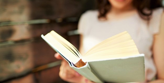 brunette-woman-holding-a-book_1098-3177