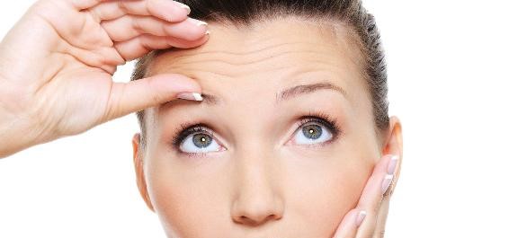 young pretty woman squeeze skin on forehead